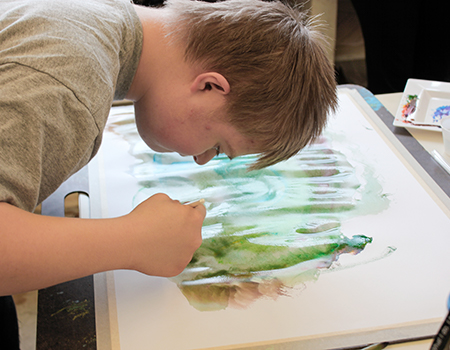 A young man painting with watercolors.