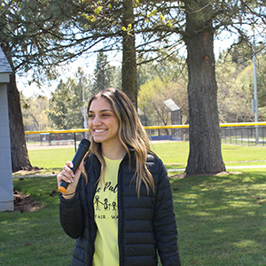Julia smiling and speaking into a microphone at the 2022 Walk and Roll event