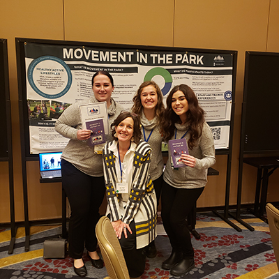 Victoria, Maddie, Kellie and Olivia post in front of the Movement in the Park poster at the conference. Click to enlarge.
