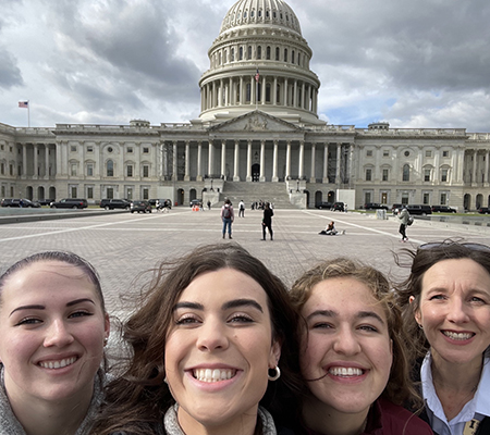 Victoria, Kellie, Maddie and Olivia, smile for a selfie in front of the Capitol Building. Click to enlarge.