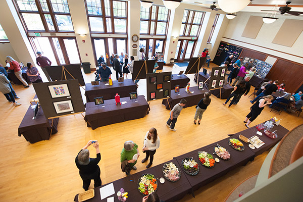 An overhead view of the many different paintings and artwork set up at the 1912 Center for the artAbility Showcase.