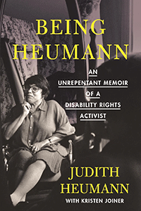 Book cover with an image of Judith Heumann sitting in her wheelchair across the cover. It is in black and white. Judith is smiling slightly at the camera and putting her index finger on her chin as if in thought. She is wearing glasses, a button-up blouse and shorts. She has short dark hair. The room around her is cluttered with different personal items. 