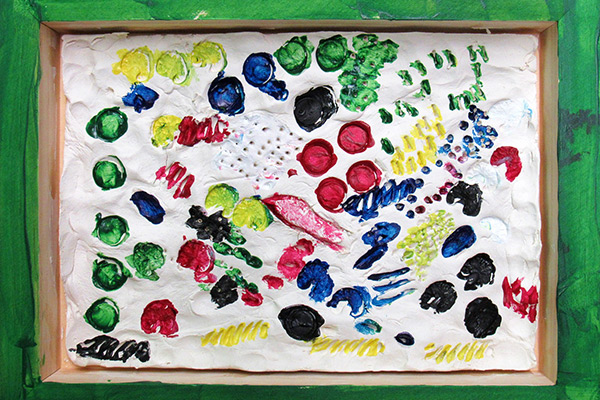 Kristin's clay piece in a wooden frame showing textures and colors. Click to enlarge image.