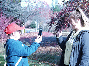 A student volunteer poses for a photo during a photography workshop.