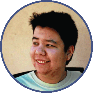 Cory is looking off to the side with a wry smile on his face. His hair is short and dark and he is wearing a light green t-shirt.
