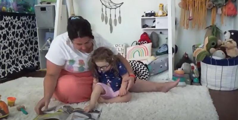 The Pause Video Fact Sheet showing a mother sitting on the floor with her daughter, reading a book together.